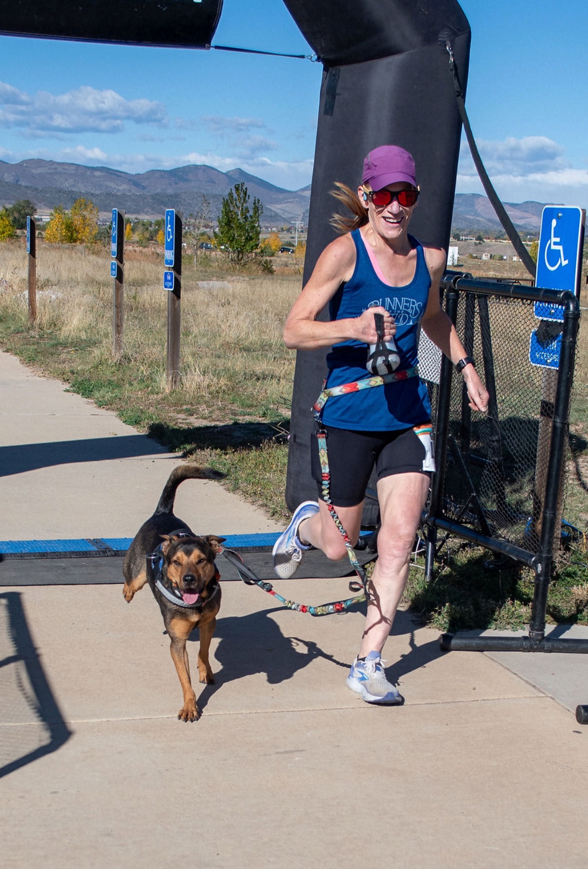 Amanda and her rescue dog Summit crossing a race finish line together
